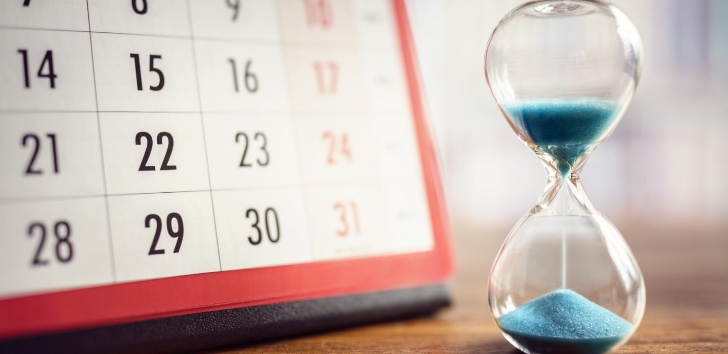Hour glass and calendar concept for time slipping away for important appointment date, schedule and deadline